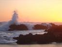 Crashing waves in sunset colors.